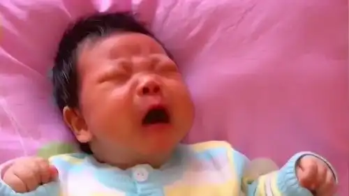 小宝宝原本还在哭,一听到手机里的笑声,宝宝的表情立马变了