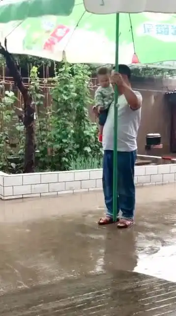 老爸为了哄娃,把祖传大伞都掏出来了,宝宝再不笑就过分了