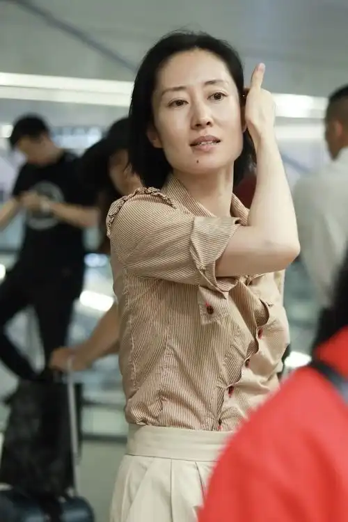 刘敏涛在机场真低调衬衫配高腰裤清新大气,橙红色鞋子真有活力
